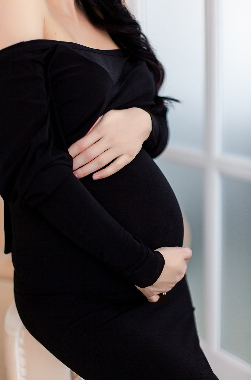 Pregnant woman in a black dress, contemplating how to get pregnant quickly. 